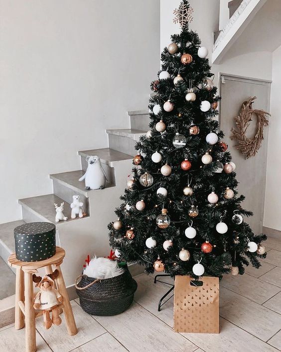 a modern Christmas tree with white baubles, snowflakes and bows and nothing else looks clean, chic and strikes with its natural beauty