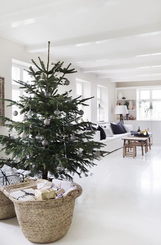 a modern Scandi Christmas tree with navy, silver, green and clear ornaments plus lights and buntings is a beautiful idea