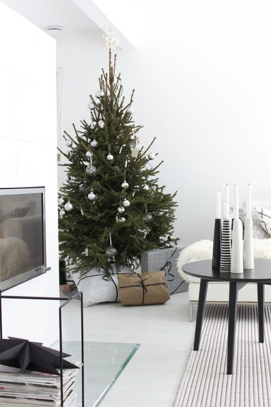 a Christmas tree with no decor except for a bit of gold stars going up to the wall and continuing there is a gorgeous idea for a modern or minimalist space